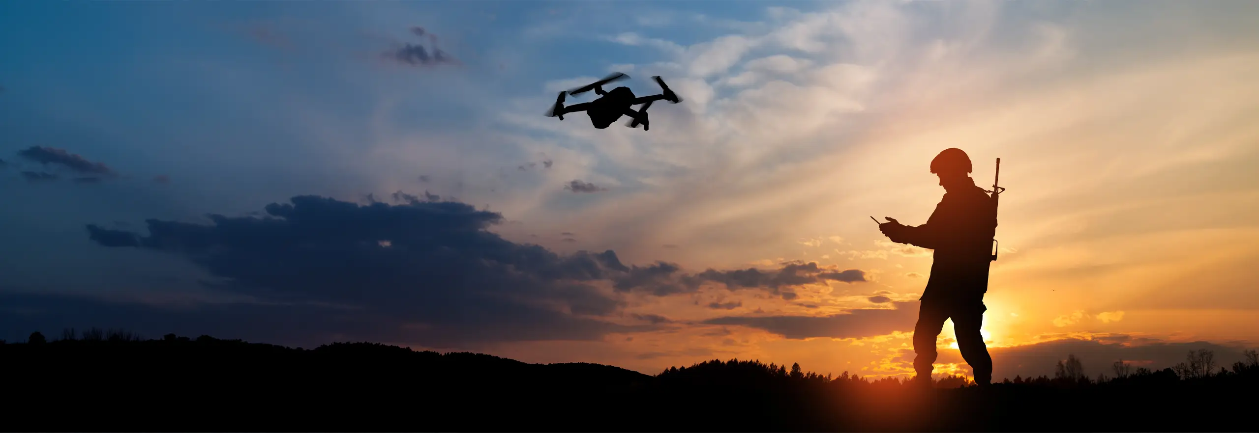 soldier flying drone at sunset
