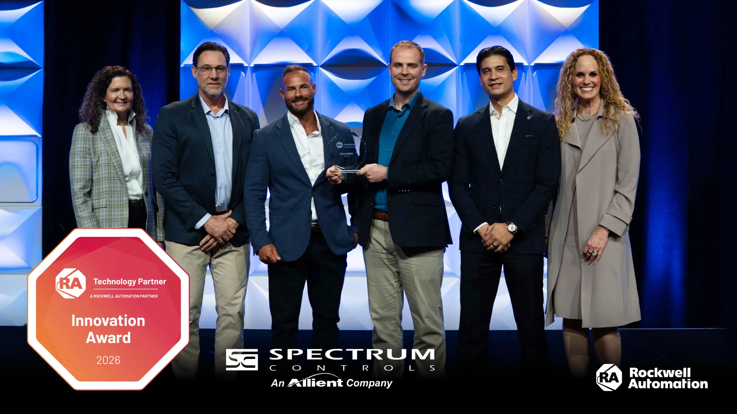 People standing smiling because Spectrum Control (Allient Bellevue) team won the Rockwell Automation PartnerNetwork™ Innovation Award 202.